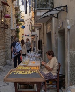 A pasta maker at work in the famous Strada del Orecchiette, historic centre of Bari Vecchio,