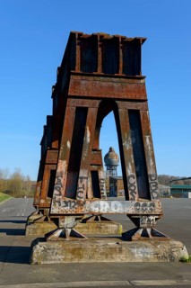 Rusty steel structures with graffiti in front of a clear blue sky in an abandoned industrial