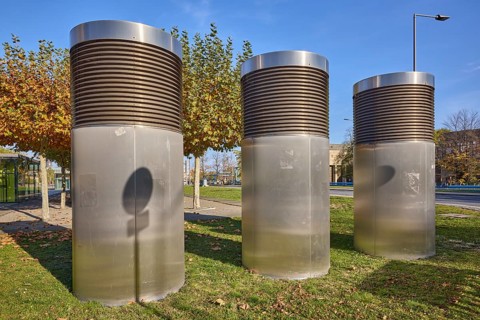 Exhaust air ducts for building air conditioning, city trees, lawn, blue cloudless sky, Dresden,