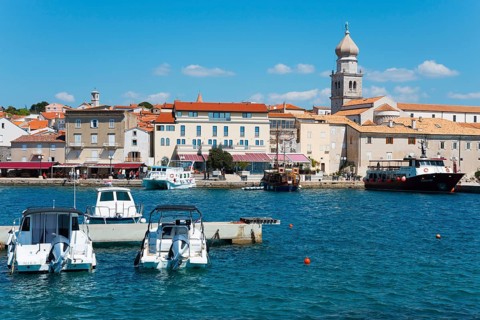 Various boats dock at the waterfront, with buildings and a bell tower in the background, Old Town,