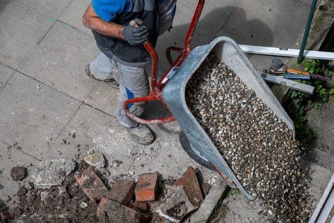 Construction worker empties wheelbarrow with gravel, Stuttgart, Baden-Württemberg
