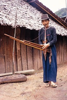 Elderly Laotian man playing a musical instrument, Northern Thailand, Asia 1971