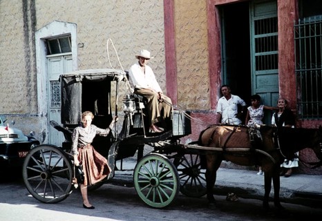 Female tourist in front of the Surrey horse-drawn carriage, Mexico, around 1961, Central America