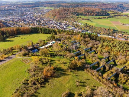 Hilly landscape with a village, autumnal trees and extensive fields in the countryside, high ropes