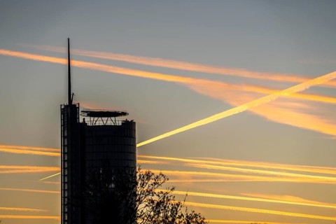 Condensation trails from aircraft flying at high altitude, evening sky, after sunset