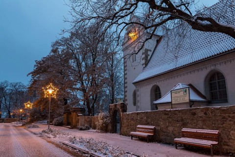Old church with illuminated poinsettia, snowy and at dusk, Coswig, Saxony, Germany, Europe