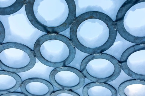 Surface of metal rings, partially covered with snow, detail of the art installation Wunderhorn by