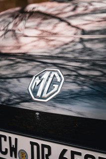MG logo on the back of a black car with reflective roof, e-car sharing vehicle from Deer Mobility,