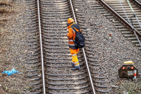 Worker on the railway tracks, after the end of his shift, walking home from the tracks, North