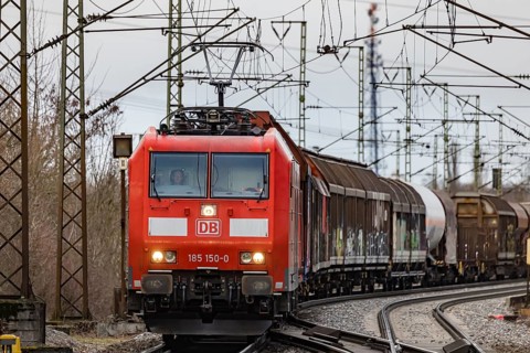 Goods train travelling on the winding Schuster Railway, overhead lines and infrastructure.