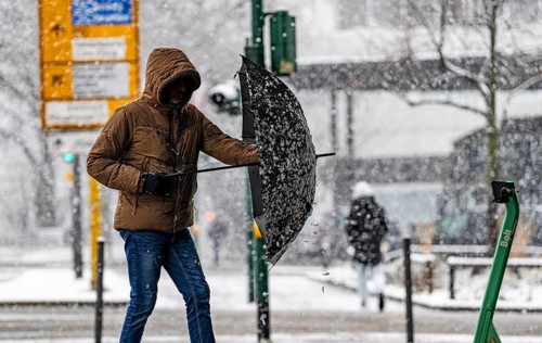 Winter weather, heavy snowfall, city centre traffic, passers-by in the snow, North