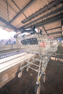Row of shopping trolleys under a covered area with sunbeams, Kaufland Calw multi-storey car park,
