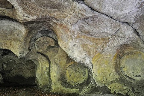 Grooves and circles in the sandstone rock from carving millstones at the Hohllay cave in Berdorf,