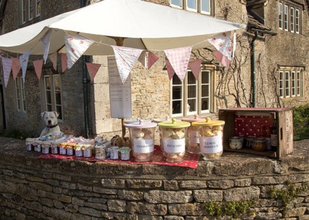 Dog and garden produce stall and street in the village of Lacock, Wiltshire, England, UK