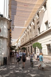 Fabric spread over buildings to provide shade in busy shopping street called Velazquez in central