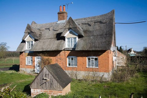 Traditional thatched cottage with well in garden, Sutton, Suffolk, England, United Kingdom, Europe