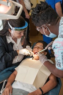 Female volunteer dentist provides dental services through Mission Smiles mobile dental clinic in