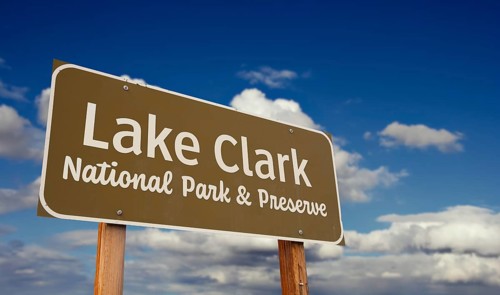 Lake clark national park and preserve (alaska) road sign against blue sky and clouds