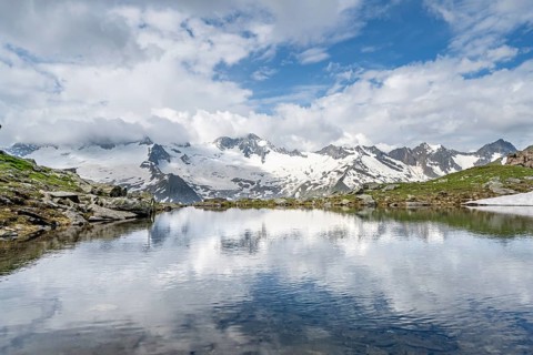 Picturesque mountain landscape with mountain lake, mountains and glaciers reflected in the
