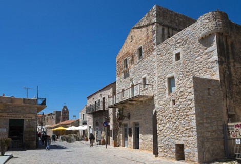 Sunny scene in an old town with historic stone buildings and people walking, Areopoli, Areopolis,