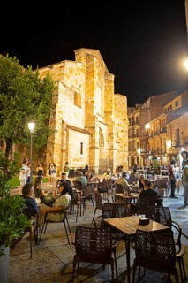 Restaurants on the Plaza Mayor at night, behind the Romanesque church Iglesia de San Juan de Puerta