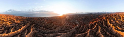 Panorama, landscape of eroded hills, badlands at sunset with Lake Issyk Kul, aerial view, Canyon of