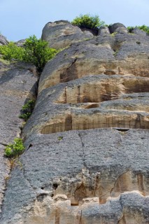 Rock face with lush vegetation under a blue sky at a sunny time of day, rock relief, Horsemen of