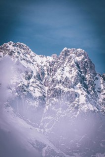 Majestic, snow-covered mountain peaks under a blue sky create a frosty atmosphere, Kaisergebierge,