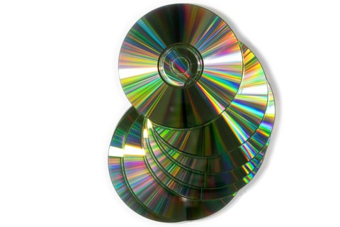 A pile of glittering CDs stacked on top of each other, white background
