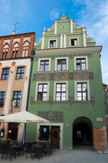 Green historic building with versatile design and next to a street café, Market Square, Poznan,