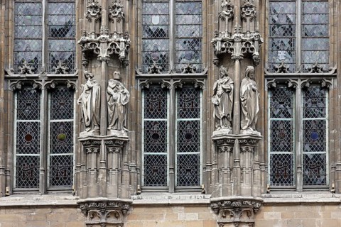 Historic town hall Stadhuis, partial view of the façade in Flamboyant Gothic style with sculptures,