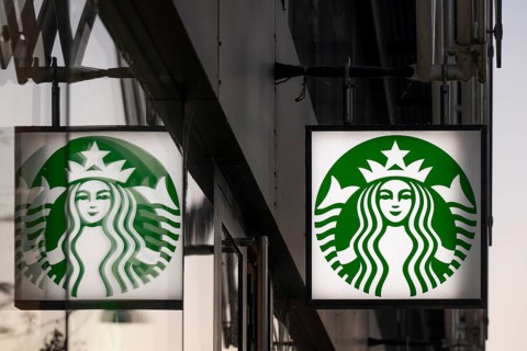Illuminated Starbucks logo reflected in window pane, city centre, Copenhagen, Denmark, Europe