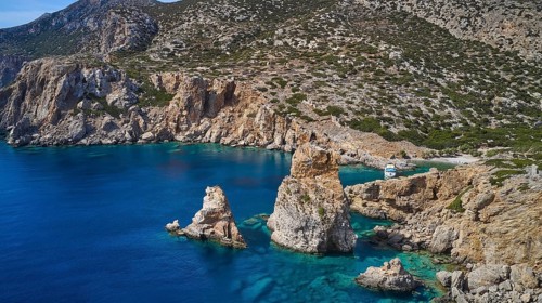 Palatia Beach, Palatia, cliff landscape with offshore rocks and a boat in the clear water, boat