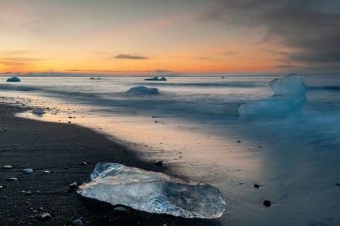 Small icebergs on the beach during sunset, long exposure, Diamond Beach, glacier lagoon Jökulsárlón