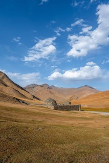 Historic caravanserai Tash Rabat from the 15th century, with yellow hills, Atbashy district in the