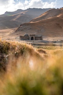 Historic caravanserai Tash Rabat from the 15th century, with yellow hills, Atbashy district in the