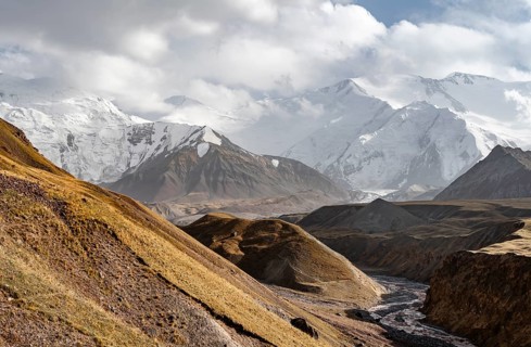 Achik Tash river, Achik Tash valley, behind glaciated and snow-covered mountain peak Pik Lenin,
