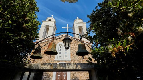 Three church bells in front of a stone wall under a deep blue sky, Koroni, Byzantine fortress,
