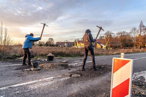 Climate activists chop up the asphalt of a road to erect obstacles, barricades, to prevent the