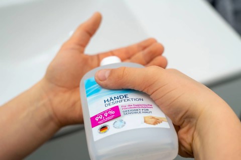 Domestic hygiene, sanitising hands with a hand sanitiser solution, boy 9 years old