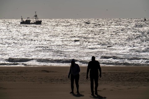 Strollers on the beach of Scheveningen, shrimp cutter, Netherlands