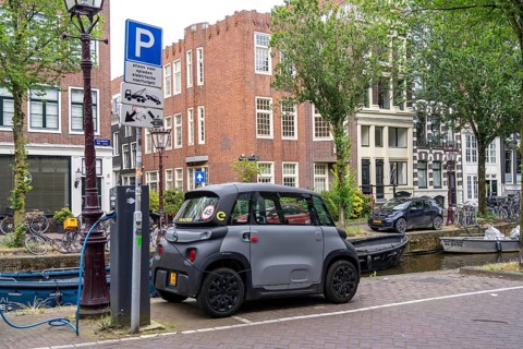 Mini car parked in the old town, Blauwburgwal canal, city centre of Amsterdam, Rocks Electric from