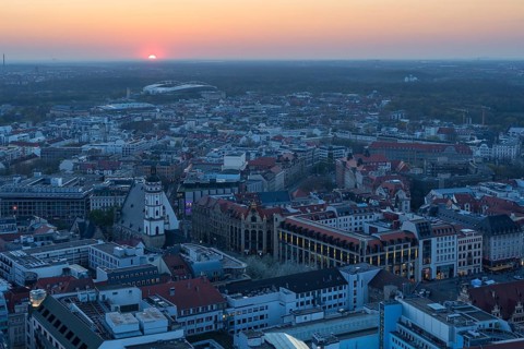 View of the city from the City Tower at sunset, St Thomas' Church, Red Bull Arena and Auwald