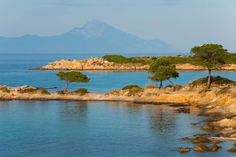 Picturesque bay with tree-covered rocks and mountain views, Karidi beach, Karydi, Mount Athos in