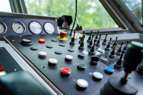 Detailed view of an industrial control panel with knobs and levers, track construction Hermann
