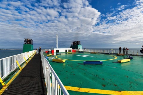 Passengers on sun deck, helipad on a ferry between Ireland and Wales, spring clouds, Ireland,