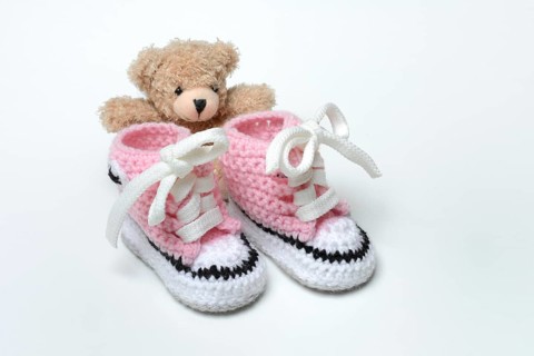Baby shoes and teddy bear, white background