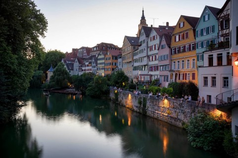 View in summer from the Neckar bridge onto the Neckar front with historic buildings, collegiate