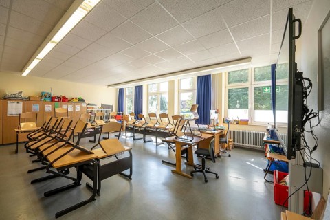 Classroom of a fourth grade, after school, the building is older but in good condition, modern