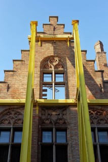 Steel girders support staircase gable of a historic house facade, gutting, construction site,